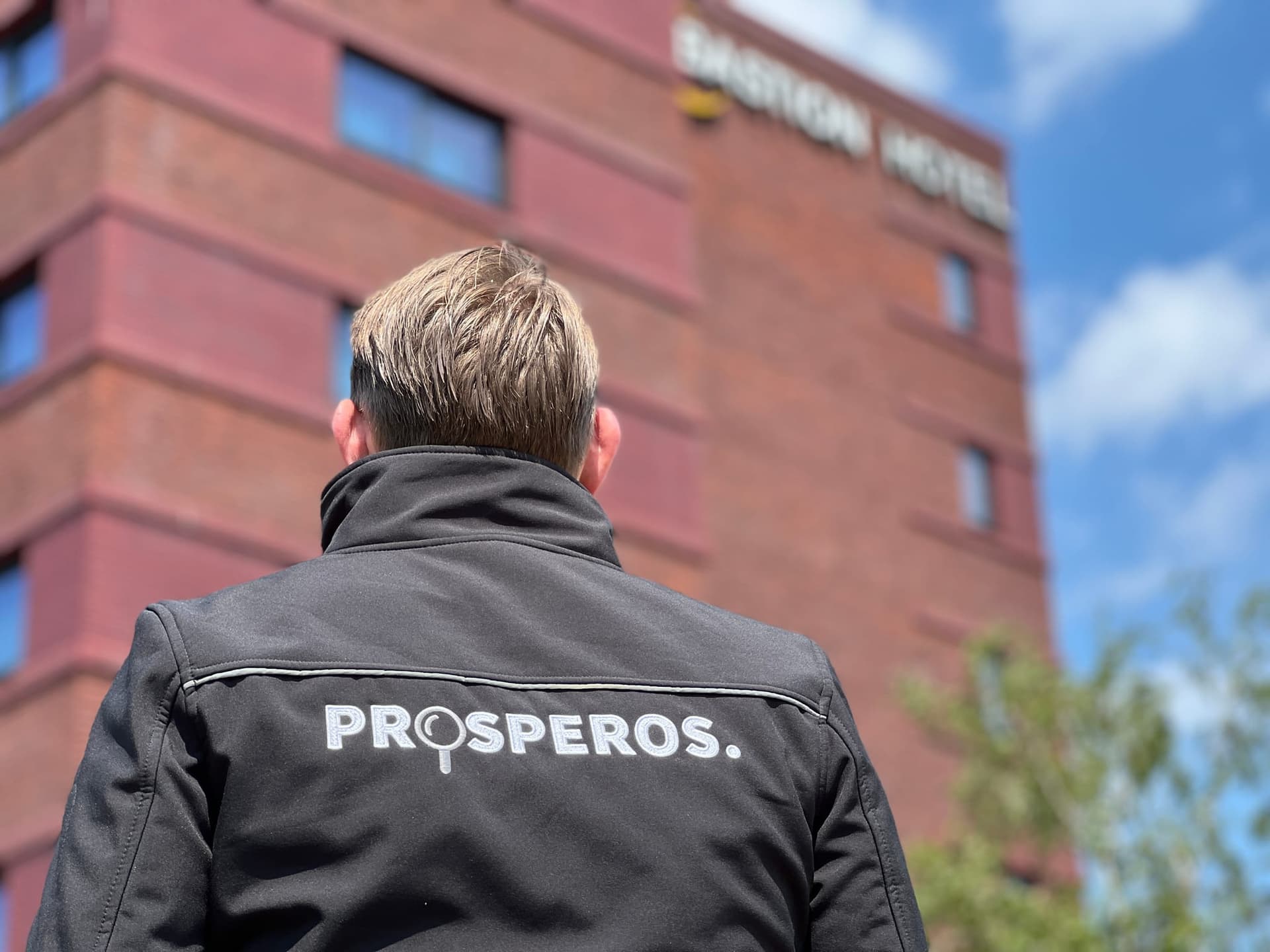 Inspecteur van Prosperos bij een hotelgebouw
