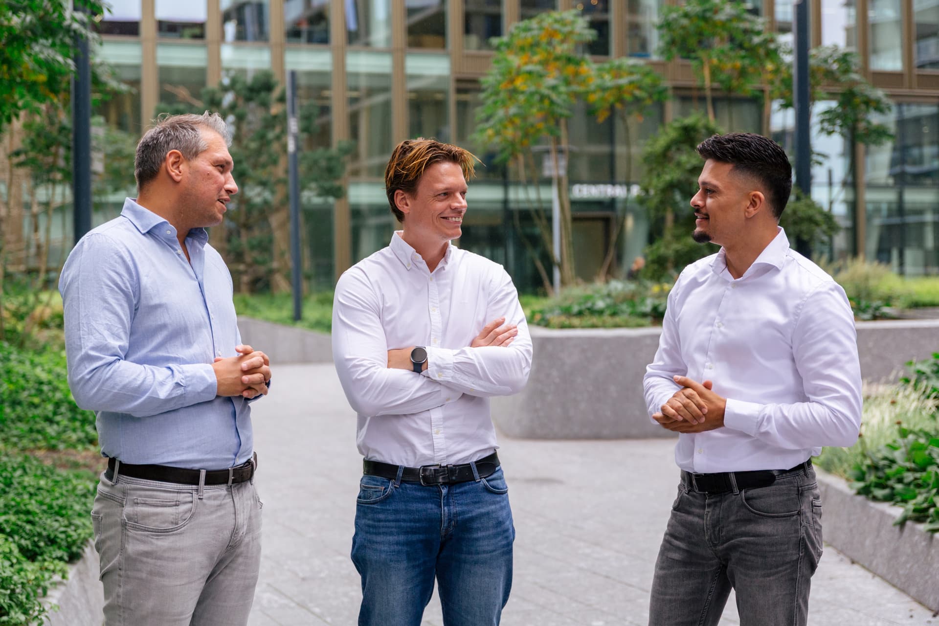 Drie collega's van Prosperos in gesprek tussen de kantoorgebouwen in Amsterdam