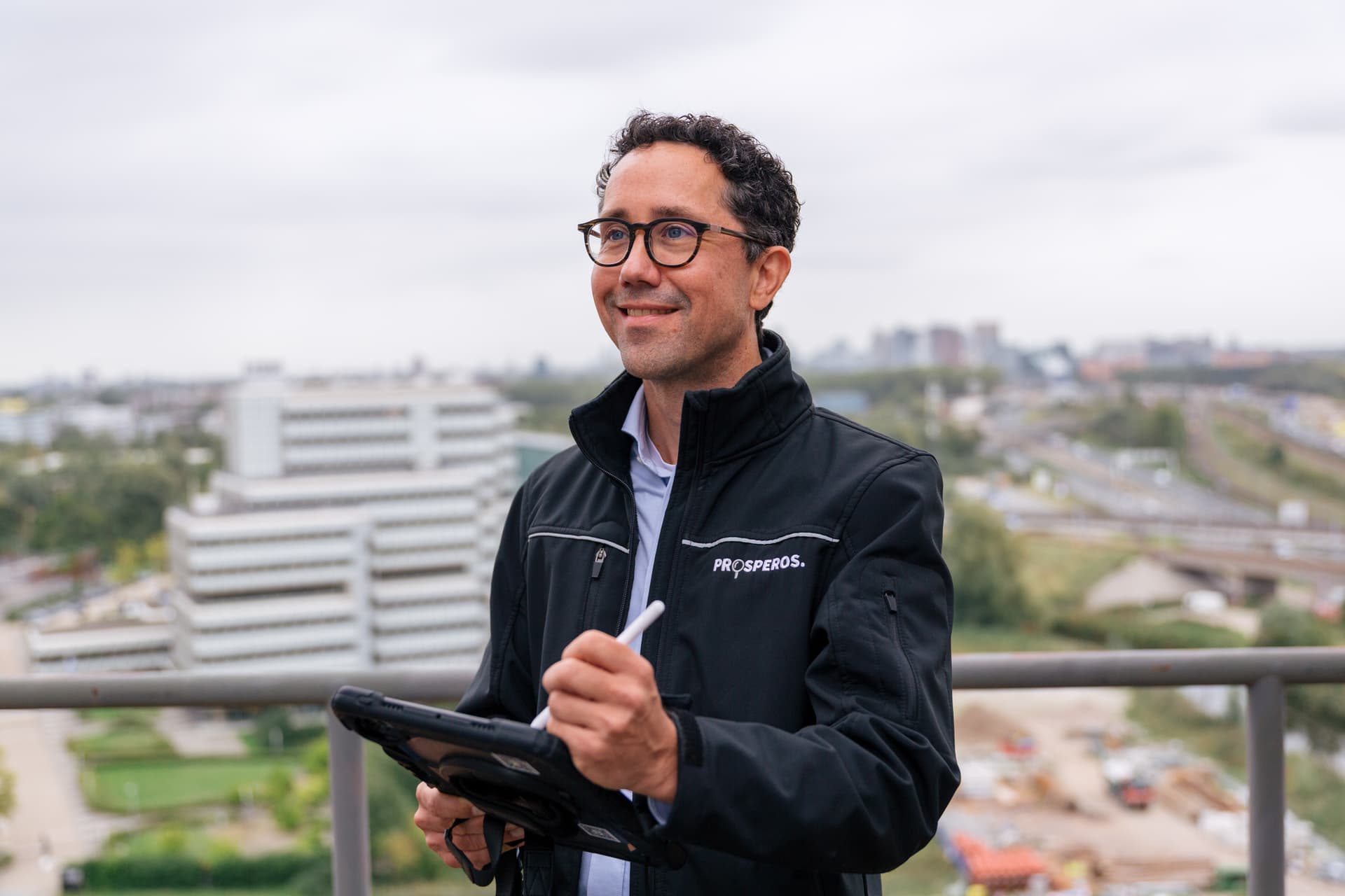 Energieadviseur van Prosperos met tablet op een dakterras met uitzicht over de stad