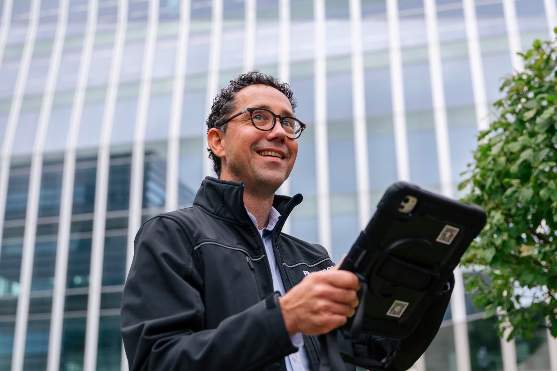 Energieadviseur van Prosperos met een tablet buiten bij een gebouw